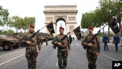 Manm Enfantri Naval la poze pou yon foto sou avnu Champs-Elysee devan Ach Triyonf la anvan parad Bastille la derape 14 Jiye, 2023. 