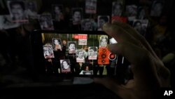 FILE - Activists display photos of journalists who have been killed in Mexico during a protest in Mexico City, July 10, 2023.