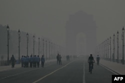 Orang-orang berjalan dalam kondisi berasap di Gerbang India di New Delhi pada 31 Oktober 2023. (Foto: Arun SANKAR/AFP)