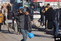 A boy carries gas canisters in Rafah in the southern Gaza Strip, Feb. 4, 2024, as fighting continues between Israel and the Palestinian Hamas group.