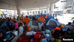 FILE - Haitian asylum-seekers set up camp in an abandoned gas station while they wait to attempt to cross into the U.S. by an appointment through the Customs and Border Protection app, at a makeshift camp in Matamoros, Mexico, June 21, 2023.