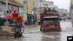 Kendaraan mencoba bergerak menerjang banjir akibat hujan lebat, di Mogadishu, 11 November 2023. (AP/Farah Abdi Warsame)