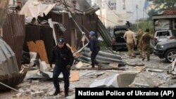 ক্রামাটোর্স্কে রাশিয়ার হামলায় ধ্বংস হওয়া একটি রেস্তোরাঁর সামনে একজন পুলিশ কর্মকর্তা এবং একজন উদ্ধারকর্মী হাঁটছেন। (এপি/ইউক্রেনের জাতীয় পুলিশ)। ২৭ জুন, ২০২৩।