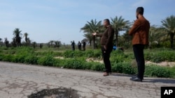 Relatives of people killed in a car by planted explosive visit the scene in Muqdadiyah, Iraq, March 22, 2023. It is not known who carried out the attack. Diyala province has seen a spike in killings.