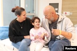 Abigail Edan, who was released after being taken hostage by the Palestinian militant group Hamas, talks with her aunt Liron and uncle Zuli in this handout picture released by Schneider Children's Medical Center of Israel on November 27, 2023.