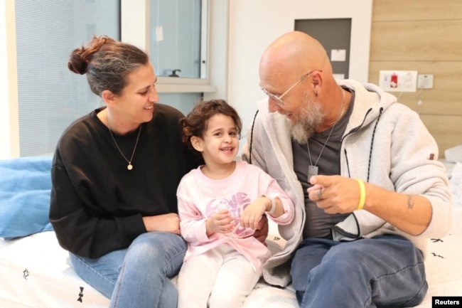 Abigail Edan, who was released after being taken hostage by the Palestinian militant group Hamas, talks with her aunt Liron and uncle Zuli in this handout picture released by Schneider Children's Medical Center of Israel on November 27, 2023.