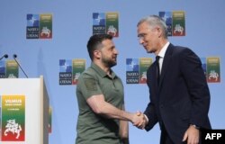 NATO Secretary-General Jens Stoltenberg shakes hands with Ukrainian President Volodymyr Zelenskyy after a joint press conference on the sidelines of the NATO Summit in Vilnius, July 12, 2023.