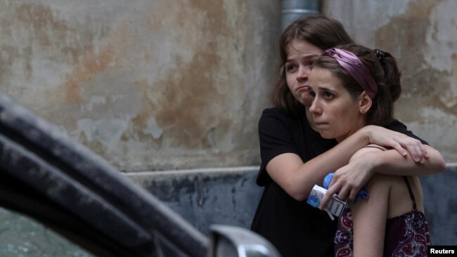 Local residents react at the site of a residential building hit by a Russian missile in Lviv, Ukraine, July 6, 2023.