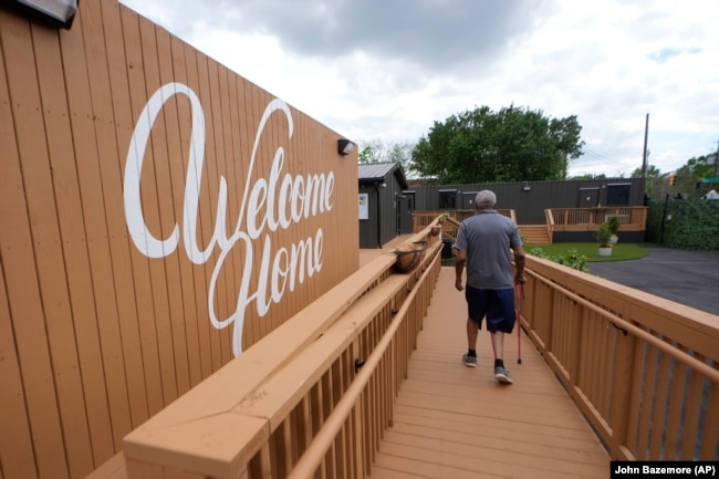 Otis Johnson walks from his apartment in Atlanta on April 12, 2024. The Melody is a housing complex made from shipping containers and is intended to help house people from Atlanta's homeless population. (AP Photo/John Bazemore)