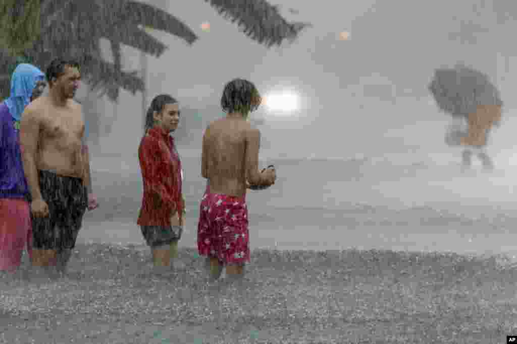 Las personas intentan cruzar una calle inundada en Miami Beach, Florida.