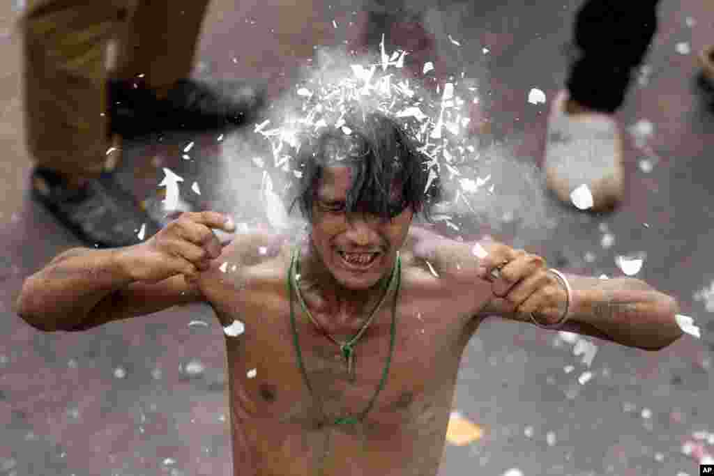 A Shiite Muslim breaks a light tube on his head during a Muharram procession in Lucknow, India.