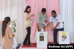 Calon wakil presiden Gibran Rakabuming Raka dan istrinya tengah memasukkan kertas suaranya dalam Pilpres dan Pileg 2024 di Surakarta, Jawa Tengah, 14 Februari 2024. (Foto: Budiman Ari/AFP)