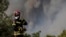 A firefighter from Romania tries to stop the fire at the village of Agia Sotira, Greece, near Athens, July 18, 2023.