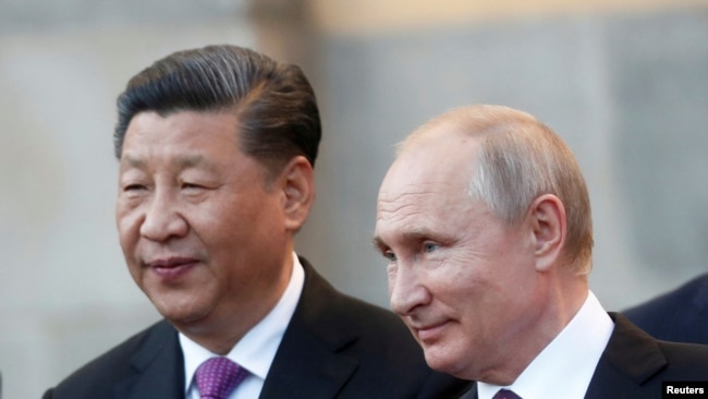 FILE - Chinese President Xi Jinping and Russian President Vladimir Putin attend a presentation of a Haval F7 SUV produced at the Haval car plant located in Russian Tula region, at the Kremlin in Moscow, Russia, June 5, 2019.