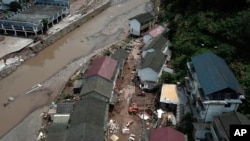 In this photo released by Xinhua News Agency, this aerial view shows damaged houses at a village following a flooding in Xiangxi in central China's Hunan province on July 2, 2023. Heavy flooding has displaced thousands of people around China.