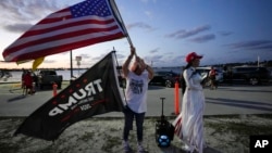 Trang Le of Orlando, right, and Maria Korynsel of North Palm Beach show their support for former President Donald Trump after the news broke that Trump has been indicted by a Manhattan grand jury, March 30, 2023, near Trump's Mar-a-Lago estate in Palm Beach, Fla.