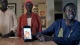 Jacob Mabil, right, speaks while showing a cell phone photo of hie nieces Nyanluak Deng, left, and Anyier Deng during an interview at his home on Wednesday, November 8, 2023, in Haslet, Texas.