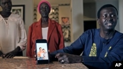 Jacob Mabil, right, speaks while showing a cell phone photo of hie nieces Nyanluak Deng, left, and Anyier Deng during an interview at his home on Wednesday, November 8, 2023, in Haslet, Texas.