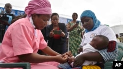 A health worker administers the malaria vaccine Oxford-Serum R21 to a child in Abidjan, Ivory Coast, Monday, July 15, 2024. (AP Photo/Diomande Ble Blonde)