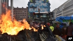 Protesters light fires during a farmers demonstration in the European Quarter outside a meeting of EU agriculture ministers in Brussels, Feb. 26, 2024.