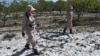 FILE - Members of a demining team look for unexploded ordnance in the Trieu Phong district of Quang Tri province, Vietnam, Jan. 6, 2020. 