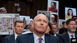 FILE - With protesters in the audience, Boeing CEO Dave Calhoun waits to testify before the Senate Homeland Security and Governmental Affairs Subcommittee on Investigations at the Capitol in Washington, Tuesday, June 18, 2024. (AP Photo/J. Scott Applewhite, File)