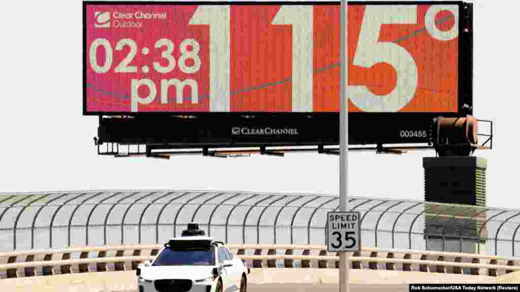 Самоуправувачки автомобил &bdquo;Waymo&ldquo; вози на Седмата улица додека температурата од 115 Фаренхајт степени (46&nbsp;Целзиусови степени) е прикажана на дигитален билборд во центарот на Феникс, Аризона, 17 јули 2023 година. &nbsp;