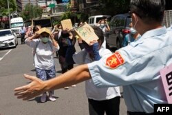 Seorang sukarelawan memandu penduduk setempat berlindung selama Latihan Serangan Udara Wanan, serangan udara sipil yang diadakan pada latihan militer tahunan Han Kuang, di Taipei, 24 Juli 2023. (Jameson WU / AFP)