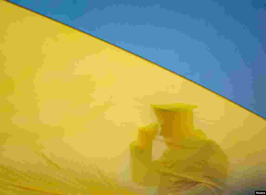 A member of the Honour Guard is seen behind Ukraine's national flag during a ceremony to mark the first anniversary of liberation the town of Bucha, as Russia's invasion of Ukraine continues, outside Kyiv, Ukraine.