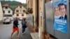 Voters arrive at a polling station in Soultz-Les-Bains, eastern France, June 30, 2024. A poster with French far-right leaders Marine Le Pen and Jordan Bardella is seen on the right.