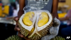 FILE - Penjual durian memamerkan durian 'Musang King' saat Festival Wisata Budaya Durian Internasional di Bentong, Malaysia, 25 November 2017. (AP/Sadiq Asyraf)