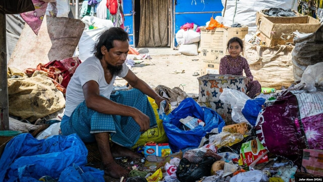 A Rohingya ragpicker and his daughter work near Delhi, India. Most Rohingya refugees do menial jobs like ragpicking for a living in India.