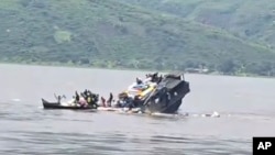 FILE - In this video frame grab, a boat sinks in the Congo river outside Kinshasa, Democratic Republic of Congo, Feb. 12, 2024.