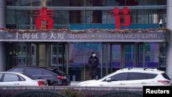 资料照片：上海浦东金融区的上海证券交易所大楼外面站着一名保安。（2020年2月3日）
