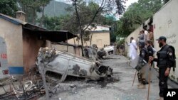 Polisi memeriksa kendaraan yang hangus dibakar oleh massa di Madyan, provinsi Khyber Pakhtunkhwa, Pakistan, Jumat, 21 Juni 2024. (AP/Naveed Ali)