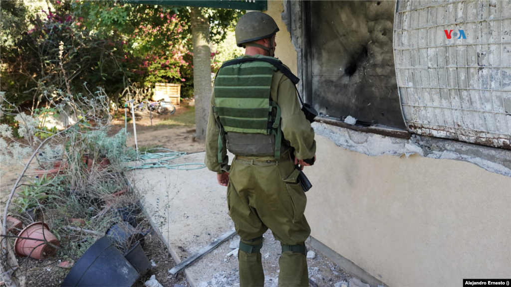 Un soldado israelí mira una de las ventanas destrozadas en el kibutz Holit por militantes de Hamas en los ataques del pasado 7 de octubre. 