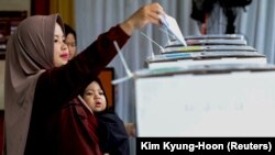 Seorang perempuan memberikan suaranya di TPS Bogor, Jawa Barat, 14 Februari 2024. (Foto: REUTERS/Kim Kyung-Hoon)