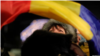 一名妇女在布加勒斯特的抗议活动中挥舞罗马尼亚国旗。