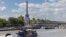 A Paris police boat (bottom left) makes its way past a cruise boat along the Seine in Paris on July 4, 2024. 