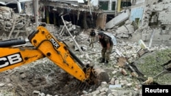 A police bomb squad member works at the site of a Russian airstrike in Kharkiv amid Russia's attacks on Ukraine, June 23, 2024. 