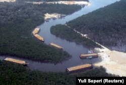 Pemandangan udara menunjukkan tongkang berbaris menunggu memuat pasir, untuk diekspor ke Singapura, dari tambang pasir di Pulau Bintan, 24 Februari 2007. (Foto: REUTERS/Yuli Seperi)