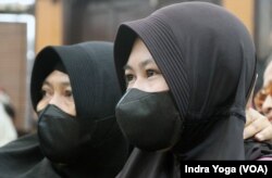 Siti Khotimah (kanan), menangis mendengarkan hakim membacakan hukuman yang diterima oleh majikannya dalam sidang putusan tindak kekerasan majikan terhadap PRT di Pengadilan Negeri Jakarta Selatan, Senin (24/7) sore. (VOA/Indra Yoga)