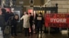 一群香港示威者在伦敦抗议香港经济质易办事处农历新年酒会，网名“揽炒巴"的香港民主派人士刘祖迪(图中手持抗议纸牌)2月13日傍晚带领示威者在市中心国宴厅(Banqueting House)外示威（美国之音/郑乐捷）