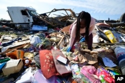 Kimberly Patton surveys through the belongings at the spot of a family member's home after a tornado destroyed the property March 26, 2023, in Rolling Fork, Miss.(AP Photo/Julio Cortez, File)