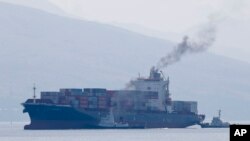 FILE - Cargo ship M/V Bavaria is assisted by tug boats as it prepares to dock at Subic port, Philippines, May 30, 2019. The head of the United Nations called Monday for maritime nations to chart a course for the shipping industry to reduce its climate-harming emissions.