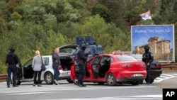 Polisi Kosovo menggeledah kendaraan di persimpangan jalan menuju Biara Banjska selama operasi yang sedang berlangsung di desa Banjska, Kosovo, 25 September 2023.