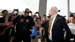 WikiLeaks founder Julian Assange, right, arrives, surrounded by the the media, at the United States courthouse where he is expected enter a plea deal, in Saipan, Mariana Islands, June 26, 2024.
