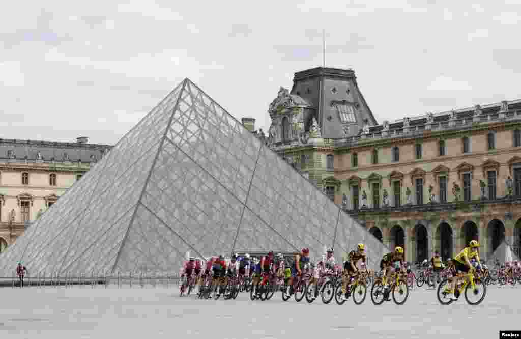 Riders pass the Louvre Museum during the 21st and final stage of the 110th edition of the Tour de France cycling race, 115 km between Saint-Quentin-en-Yvelines and the Champs-Elysees in Paris.