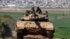 An Israeli army battle tank moves at a position along the border between southern Israeli and the Gaza Strip on Jan. 31, 2024. 