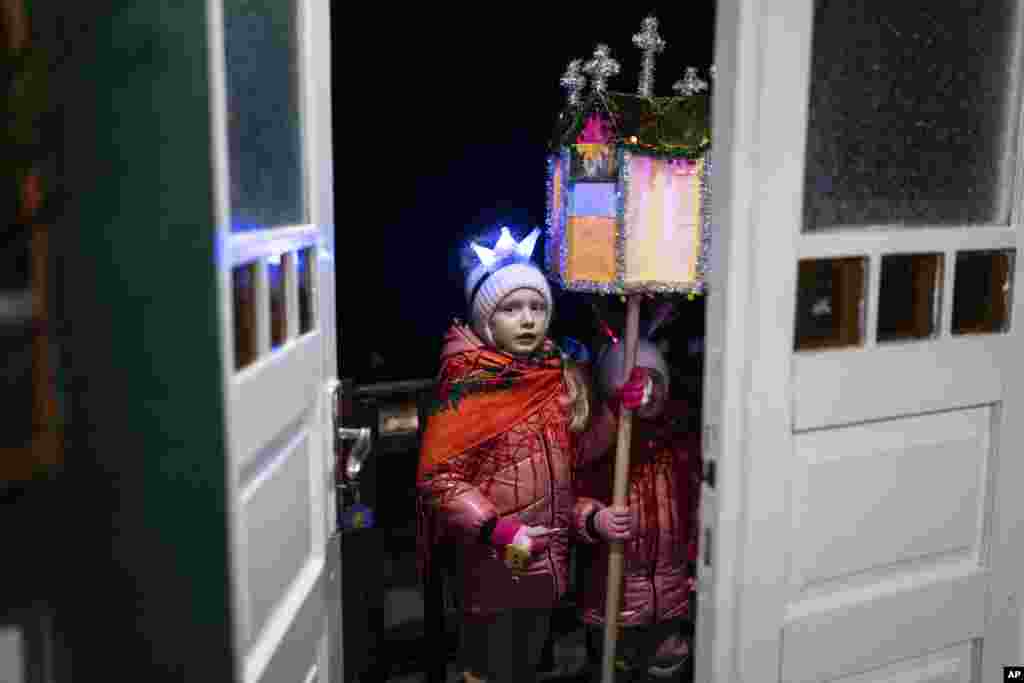 Niños cantan canciones tradicionales durante la celebración de la Navidad en la localidad de Kryvorivnia, Ucrania, el 24 de diciembre de 2023. (AP Foto/Evgeniy Maloletka).